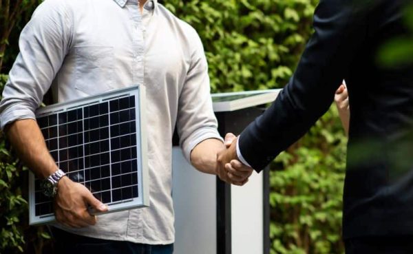 Vendeur de panneaux photovoltaïques avec client qui se serrent la main